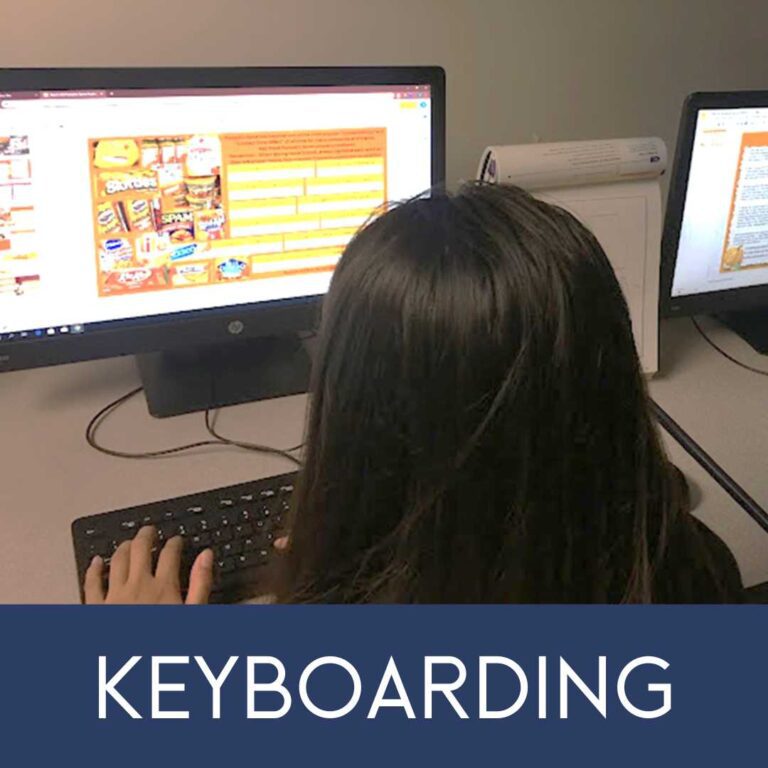 A woman sitting at a computer keyboard.