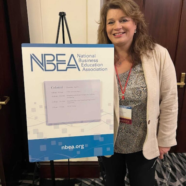 A woman standing next to a sign that says nbea.