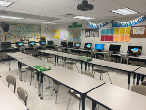 A classroom with desks and computers on it.