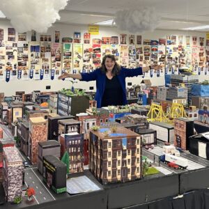 A woman standing in front of a table full of toys.